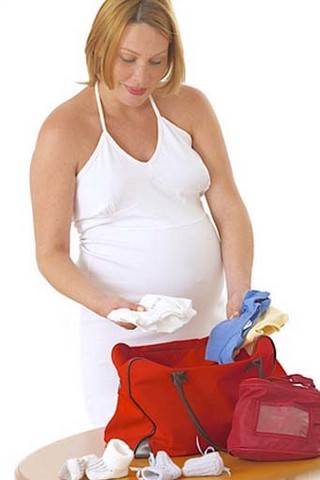 Femme enceinte préparant sa valise